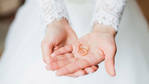 bride holds wedding bands