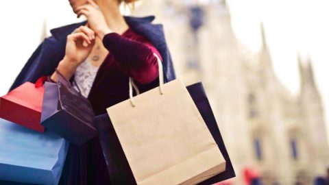 a woman is holding many shopping bags