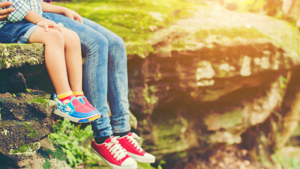 mother and her little son feets sitting at the cliffside