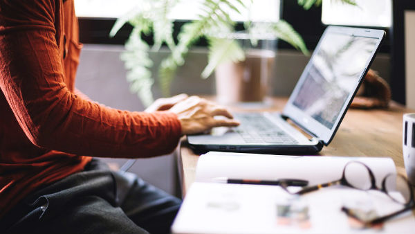 man in an office typing at his computer