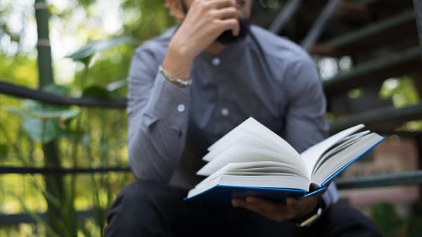 a man looking at a book thinking