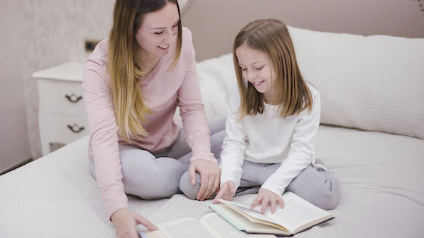 Mom and daughter reading books together