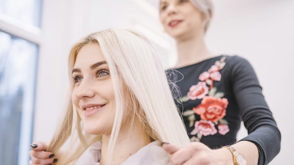 Hairdresser straightens hair for the customer