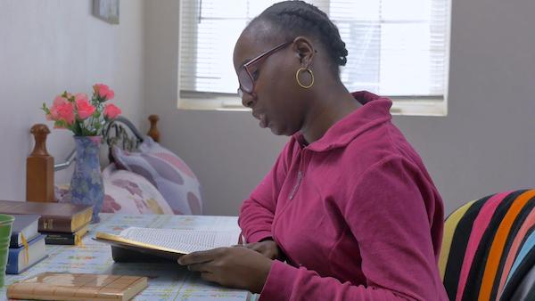 Woman in purple blouse is reading