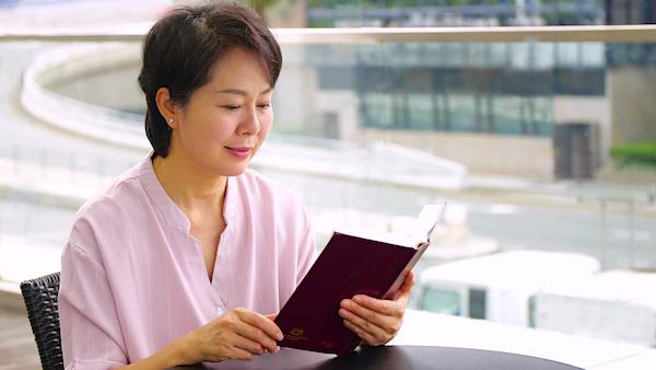 A sister is reading God's words happily