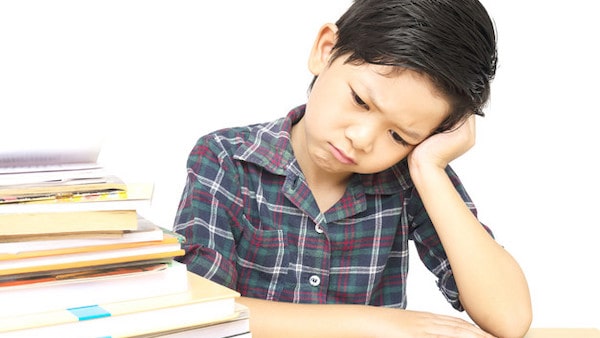 boy is unhappy doing homework